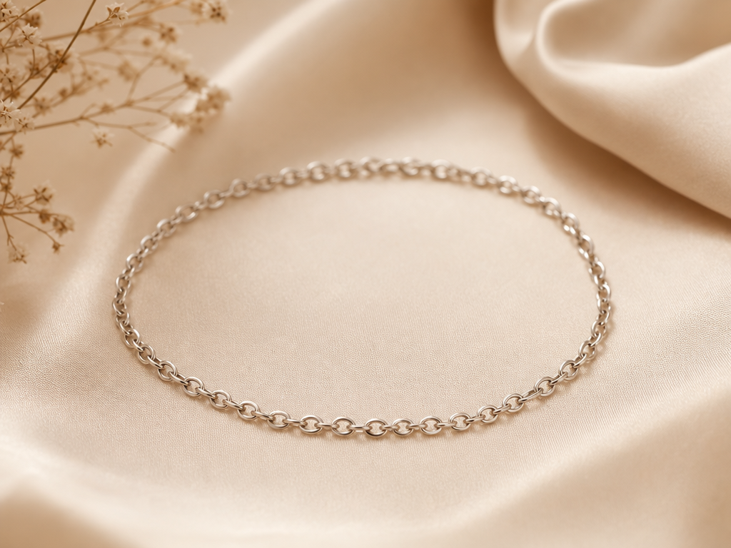 Delikates silbernes Permanent Bracelet auf beigem Seidenhintergrund